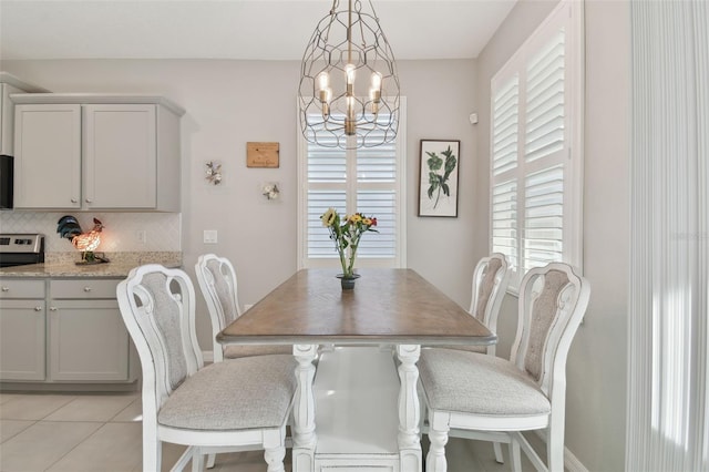 tiled dining room with a chandelier