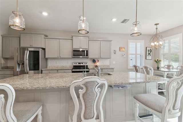 kitchen featuring gray cabinets, appliances with stainless steel finishes, and pendant lighting