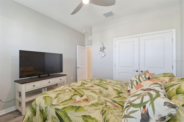 bedroom with light hardwood / wood-style flooring, ceiling fan, and a closet