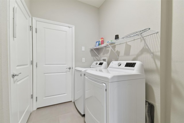 laundry room featuring washer and dryer and light tile patterned floors