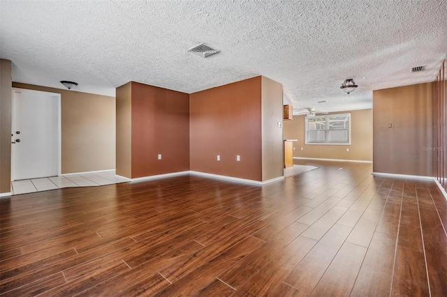 empty room with hardwood / wood-style flooring and a textured ceiling