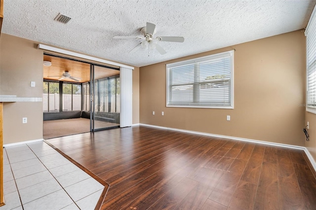 unfurnished room featuring ceiling fan, hardwood / wood-style floors, and a textured ceiling