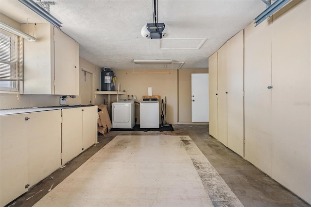 garage with a garage door opener, water heater, and washer and dryer