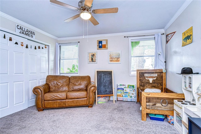 carpeted living room featuring ceiling fan, ornamental molding, and plenty of natural light