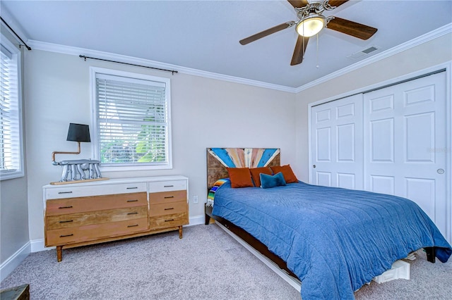 carpeted bedroom featuring crown molding, a closet, and ceiling fan