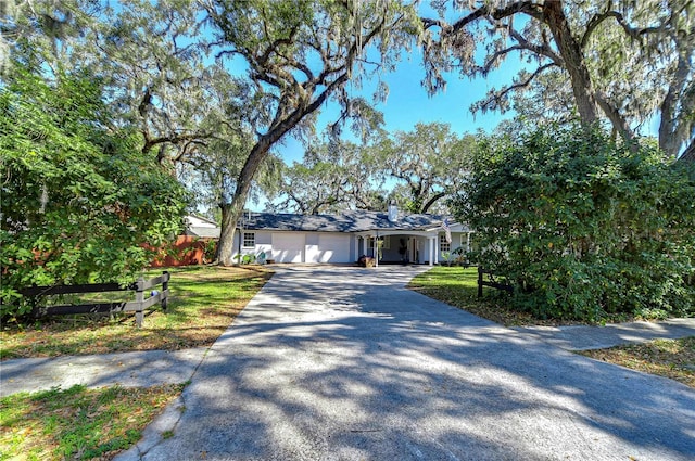 ranch-style house with a garage and a front lawn