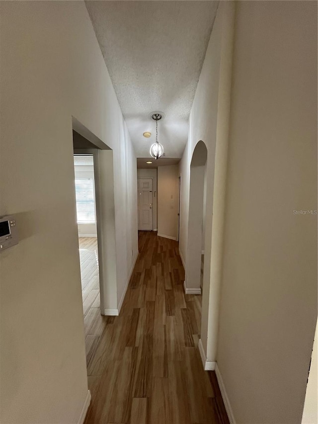 hall featuring light hardwood / wood-style floors and a textured ceiling