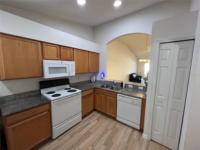 kitchen featuring pendant lighting, sink, white appliances, light hardwood / wood-style flooring, and a chandelier