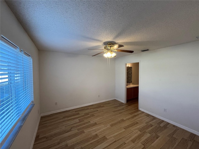 spare room with ceiling fan, wood-type flooring, and a textured ceiling