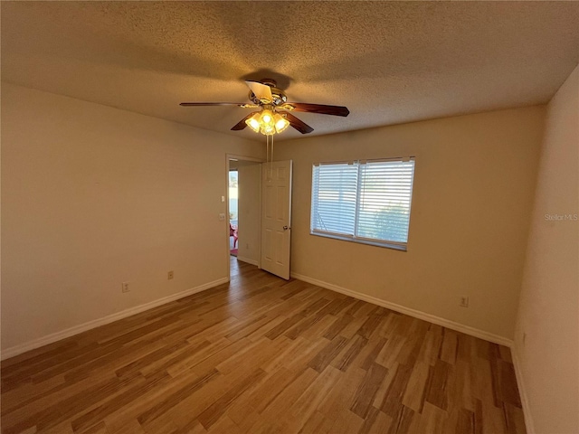 unfurnished room featuring ceiling fan, light hardwood / wood-style flooring, and a textured ceiling