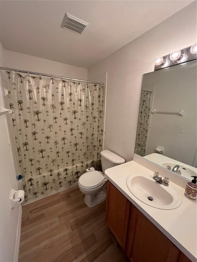 full bathroom with shower / tub combo, vanity, hardwood / wood-style flooring, and toilet