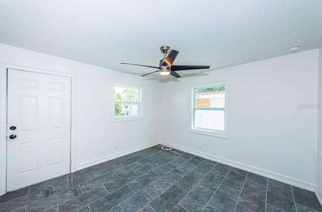 empty room with visible vents, baseboards, and a ceiling fan