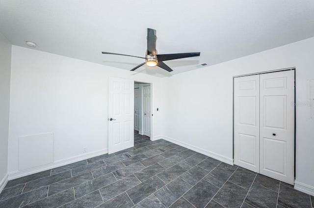 unfurnished bedroom featuring a ceiling fan, a closet, visible vents, and baseboards