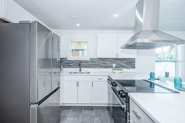 kitchen featuring backsplash, appliances with stainless steel finishes, white cabinetry, a sink, and exhaust hood