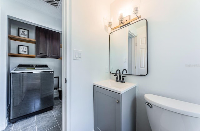 bathroom featuring washer / dryer, vanity, toilet, and a textured ceiling