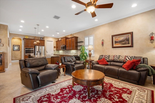 living room featuring ceiling fan, ornamental molding, sink, and light tile patterned floors