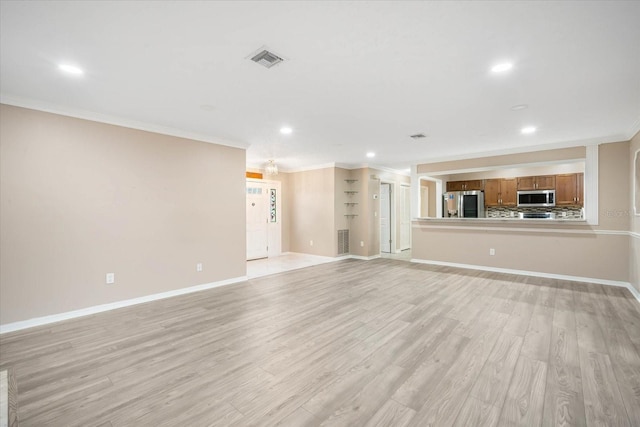 unfurnished living room with ornamental molding and light hardwood / wood-style floors