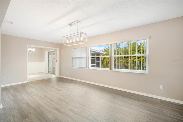 unfurnished room featuring hardwood / wood-style flooring and a textured ceiling