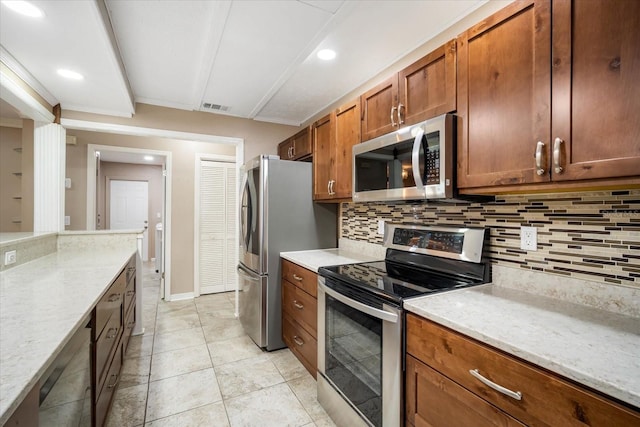 kitchen featuring light stone counters, light tile patterned floors, decorative backsplash, and stainless steel appliances