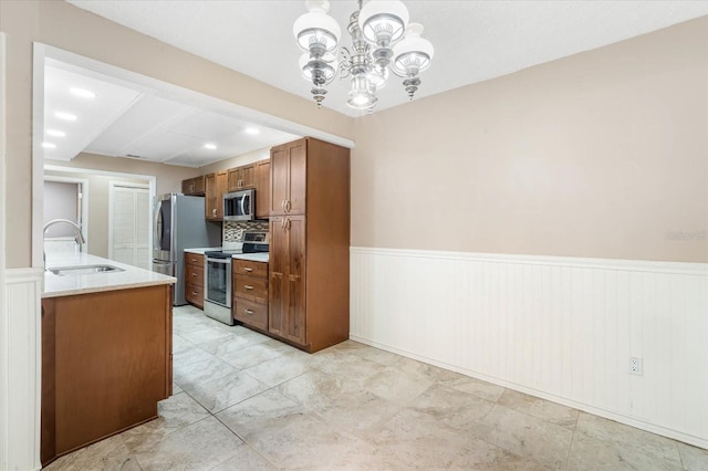 kitchen featuring tasteful backsplash, stainless steel appliances, sink, and a notable chandelier