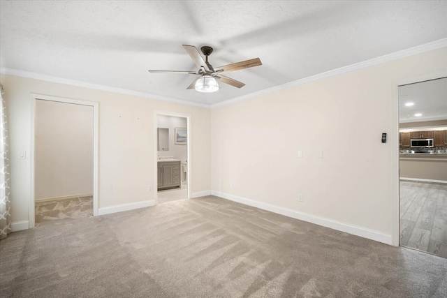 empty room featuring light carpet, crown molding, a textured ceiling, and ceiling fan