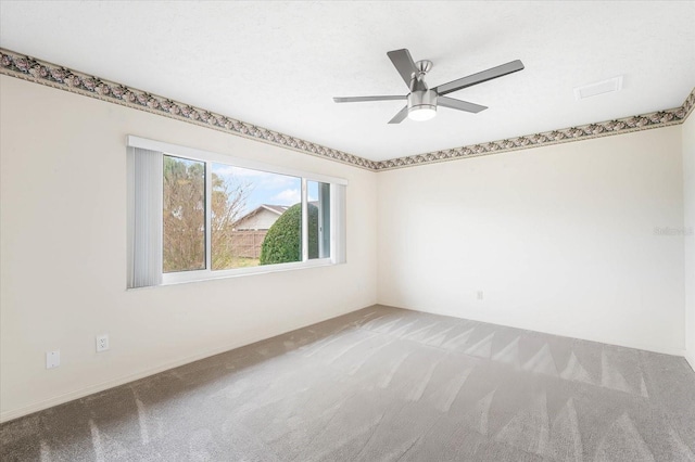 unfurnished room featuring a textured ceiling, ceiling fan, and carpet