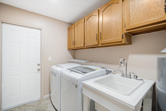 clothes washing area featuring washer and dryer, sink, and cabinets