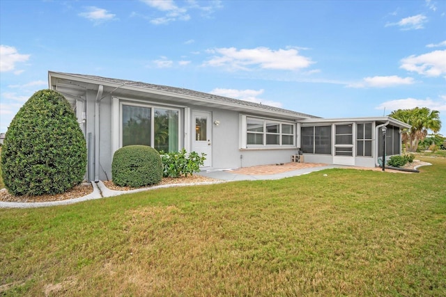 back of property featuring a yard and a sunroom