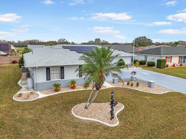 single story home featuring a front lawn and solar panels