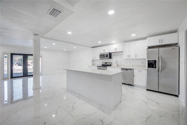 kitchen featuring white cabinetry, sink, stainless steel appliances, and a textured ceiling