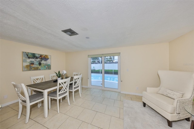 tiled dining space with a textured ceiling