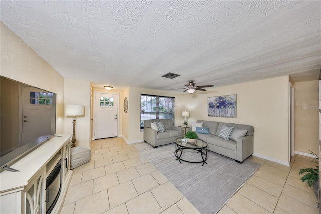 living room featuring light tile patterned floors, a textured ceiling, and ceiling fan