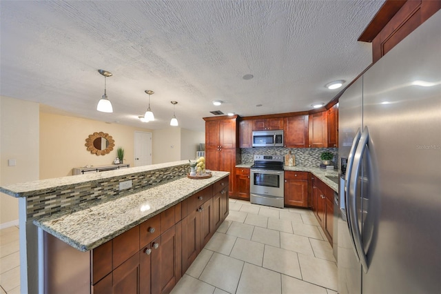 kitchen with light stone counters, appliances with stainless steel finishes, hanging light fixtures, and backsplash