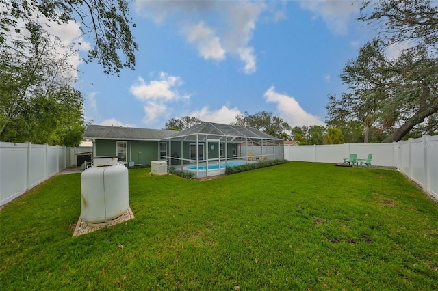 back of property featuring a fenced in pool, a yard, and glass enclosure