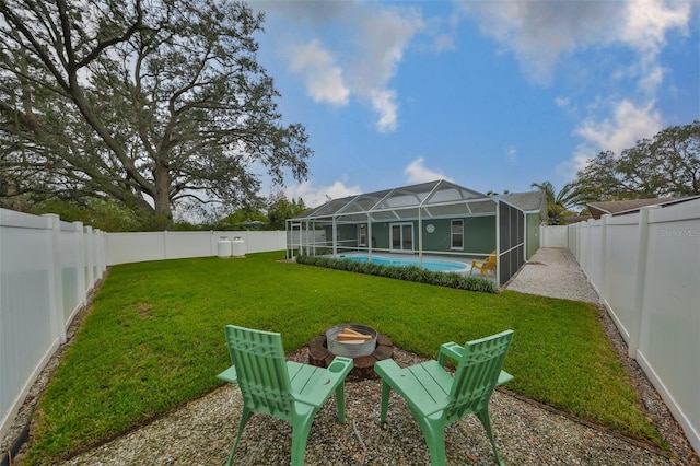 view of yard with a fenced in pool, a fire pit, and a lanai