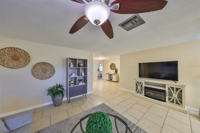 tiled living room featuring ceiling fan and a textured ceiling