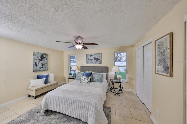 bedroom with light tile patterned flooring, a textured ceiling, ceiling fan, and a closet