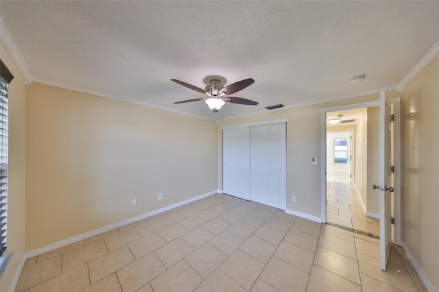 unfurnished bedroom featuring crown molding, ceiling fan, a closet, and light tile patterned floors