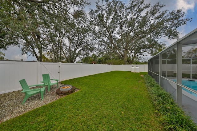 view of yard featuring a fenced in pool and glass enclosure