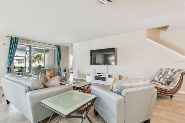 living area featuring light tile patterned floors, baseboards, and visible vents