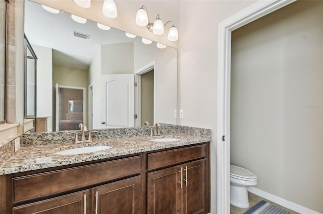 ensuite bathroom featuring toilet, visible vents, ensuite bathroom, and a sink