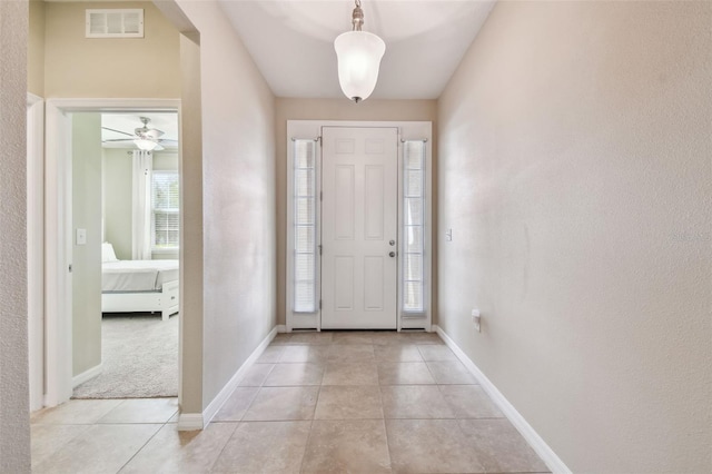 entrance foyer featuring light tile patterned floors, visible vents, and baseboards