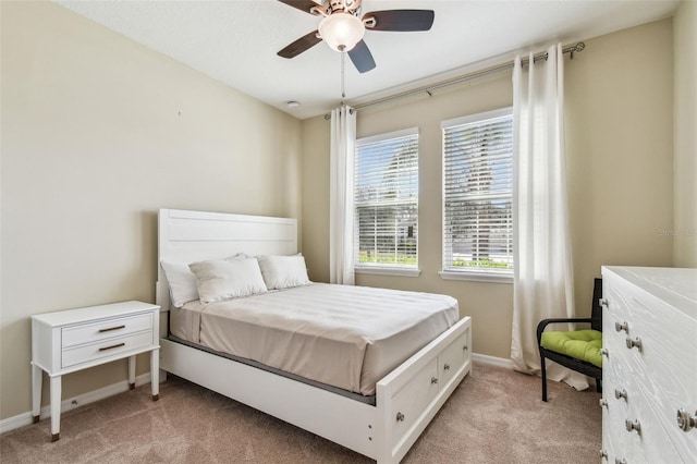 bedroom with ceiling fan, baseboards, and light carpet