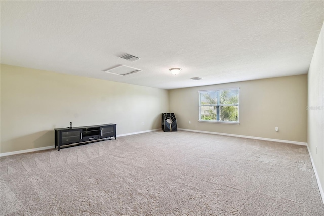 empty room with light colored carpet and a textured ceiling