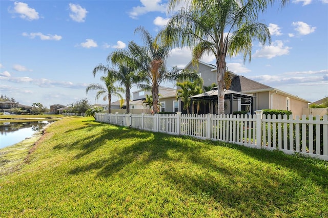 view of yard with a gazebo, a water view, and fence