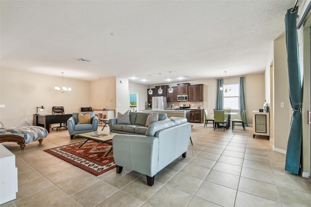 living room with a notable chandelier, visible vents, light tile patterned floors, and a textured ceiling