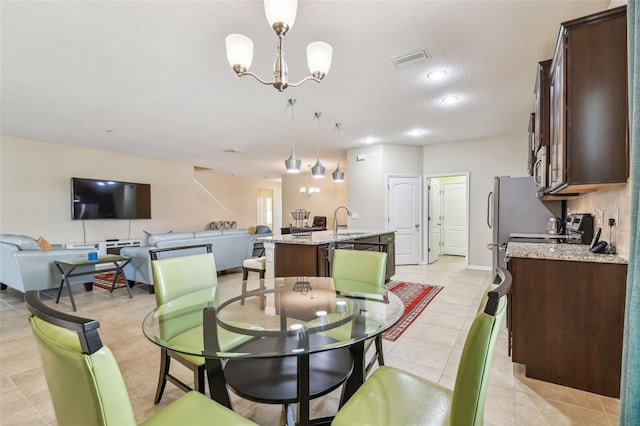 dining area with an inviting chandelier, light tile patterned flooring, visible vents, and a textured ceiling