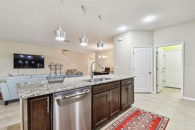 kitchen with decorative light fixtures, dishwasher, sink, a kitchen island with sink, and light stone counters