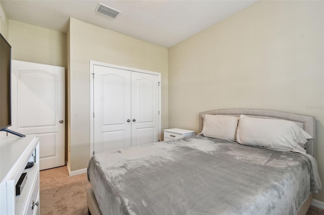 bedroom with light colored carpet and a closet