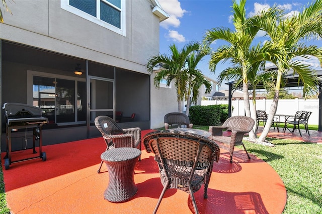 view of patio / terrace with outdoor dining area, fence, a sunroom, and grilling area